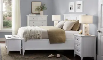 Light blue bedroom with a white bed, two nightstands, dresser, and lamps