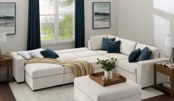 Bright living room with cream sectional sofa extended into a bed, dark blue cushions, and a large window