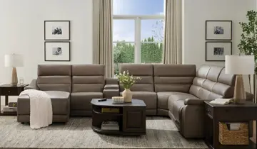 Brown leather U-shaped reclining sectional sofa in a living room with tables and lamps