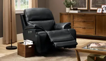 Black recliner partially extended in a living room with various wood furnishings