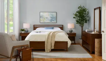 Bedroom with wooden bed, nightstands, dresser, mirror, and armchair by a window