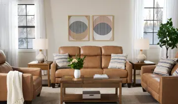 Tan leather living room set with sofa, chairs, wood tables, and lamps