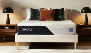 Bedroom with white mattress on a light bed frame, two nightstands, and table lamps