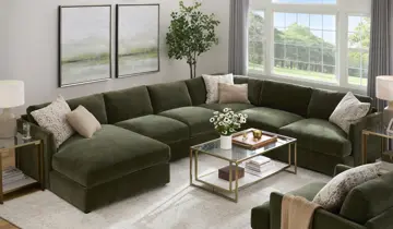 Bright living room with large U-shaped olive green sectional, glass coffee table, and sunny windows