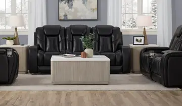 Black reclining sofa and armchair with wood coffee table in a living room