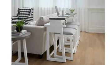 Living room with a white sofa, console table with stools, and a side table