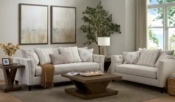 Bright living room with light upholstered sofa, loveseat, wood tables, and wall art