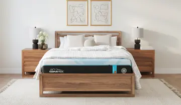 Modern bedroom with wooden bed, blue and black mattress, nightstands, and lamps
