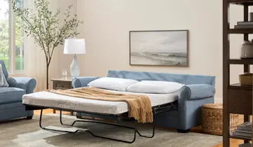 Light blue sleeper sofa with bed extended in a living room