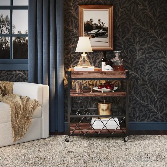 Inviting living space with a rolling wooden bar cart, white armchair, blue curtains, and dark patterned wallpaper