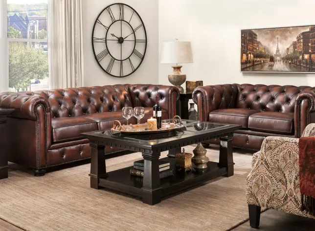 Traditional living room with brown tufted leather sofas, a dark wood coffee table, and a large wall clock