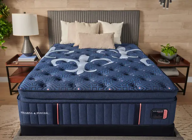 Elegant bedroom featuring a dark blue mattress with light blue patterns, a ribbed gray headboard, and wooden nightstands