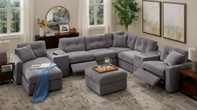 Bright living room with an extensive gray modular sectional sofa, chaise, ottoman, and recliners, near sunlit windows