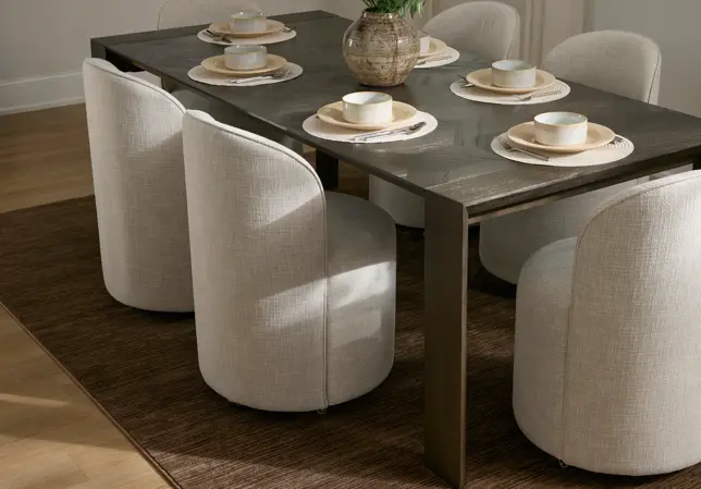 Modern dining room with a dark wood table, six light beige upholstered chairs, and place settings