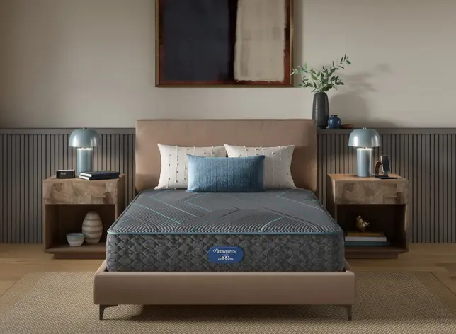 Modern bedroom with upholstered bed, gray mattress, two wood nightstands, and blue lamps
