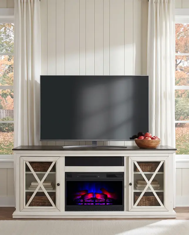 Cozy living room with a white media console, electric fireplace, large TV, and cream curtains by autumn windows