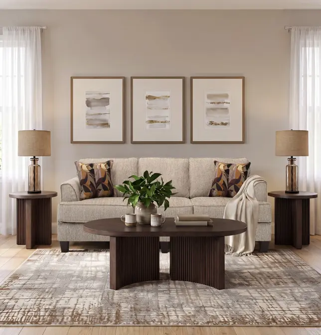 Warm, symmetrical living room with light sofa, dark wood tables, abstract art, and patterned rug